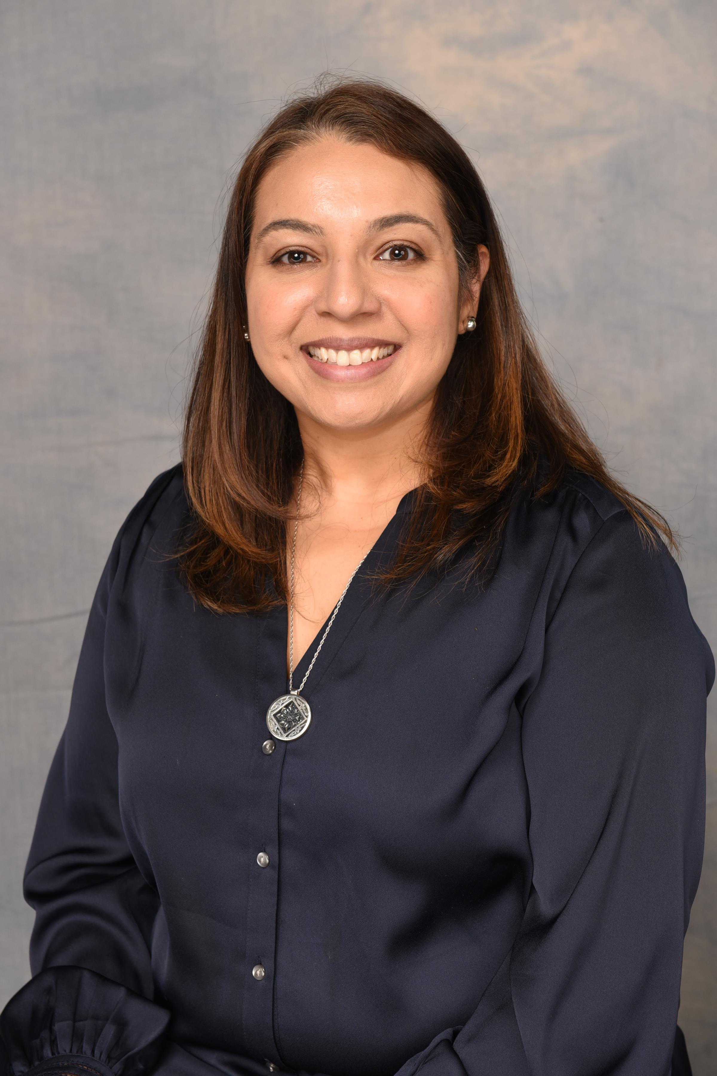 A smiling female in a dark blue shirt