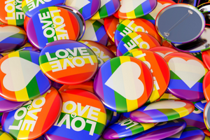 Pride month rainbow buttons with the word "love" or hearts on them. 