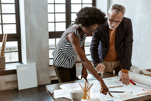 young black woman and older white man looking at paperwork in office