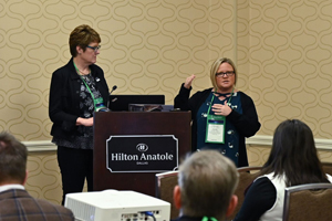 two females speaking from a podium