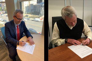 two males signing documents