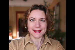 selfie of woman smiling at camera, blurred xmas tree in background