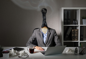 businessperson sitting at desk with burned matchtop for a head