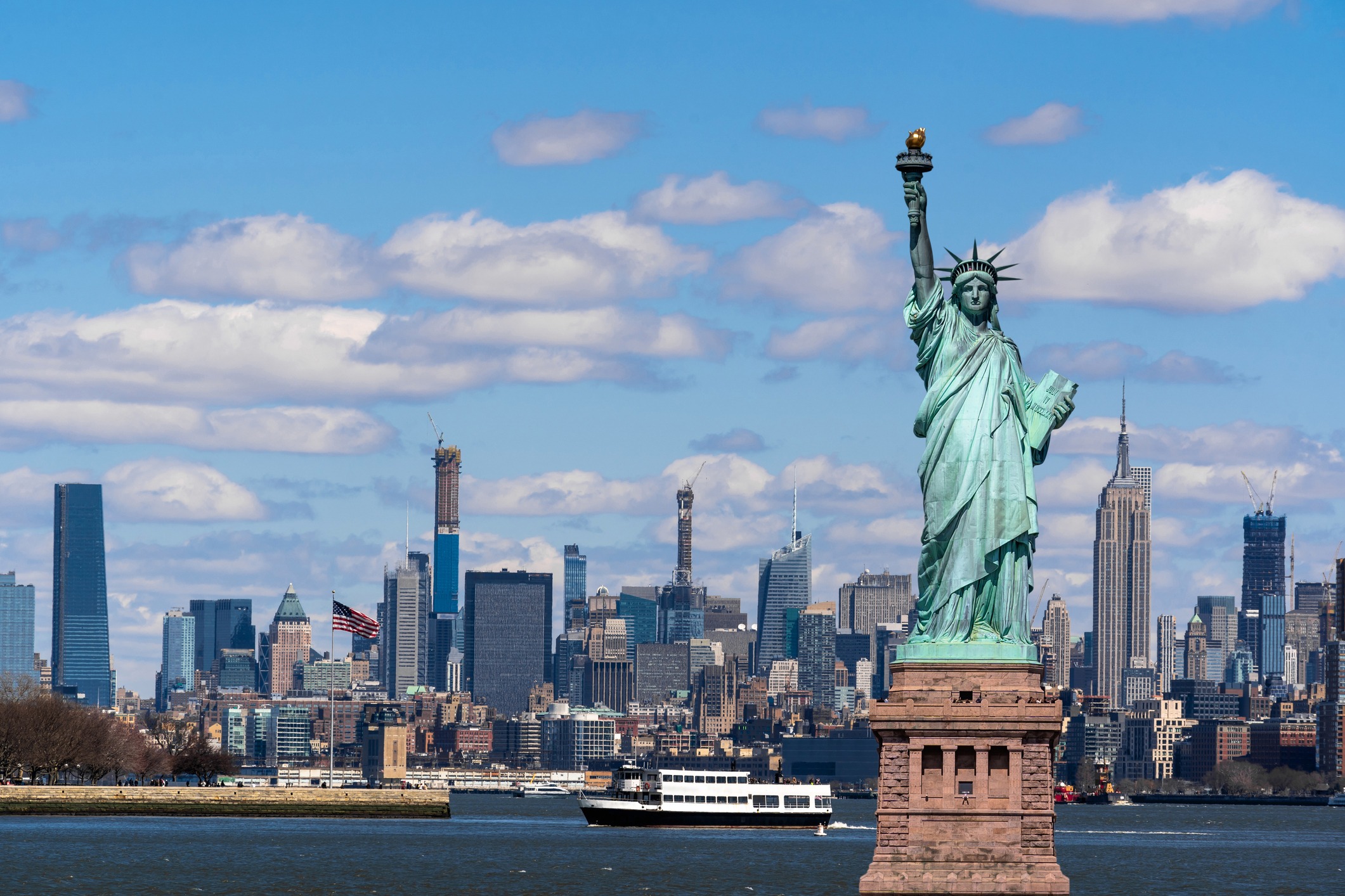 statute of liberty with the New York city skyline visible in the background 