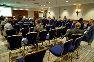 audience members converse with one another while sitting in their auditorium chairs