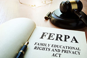Photograph of an open book with the words FERPA on it and a gavel in the background.