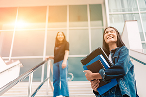 Two students on a staircase outside of an academic building.