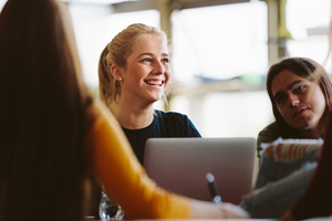 Female smiles at someone out of frame