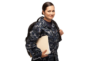 female in military fatigues holding papers and carrying a backpack