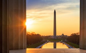 photo taken from the perspective of the Lincoln memorial looking at the reflection pool and Washington monument at sunset 