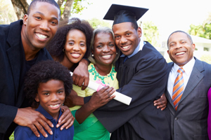 family of color hugs and smiles to celebrate the graduation of their son