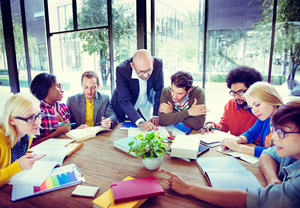 people converse and work around a table