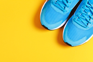 yellow background with blue athletic sneakers