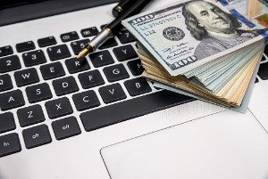 large stack of bills on top of a laptop keyboard