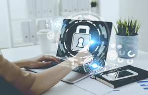 person works on their laptop as a symbol of a padlock radiates from the screen