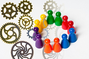 various intersecting  gears cast a shadow on a group of board game figurines