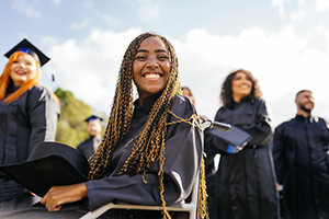 Group of students at a graduation ceremony, one of whom is utilizing a wheelchair.