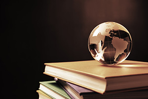 Photograph of a glass globe sitting on top of a stack of books.