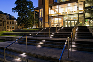 steps leading to a modern building with its inside lights on