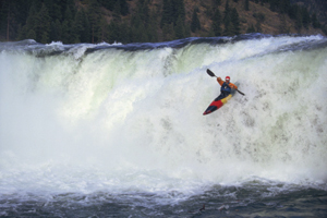 whitewater kayaker going over a waterfall