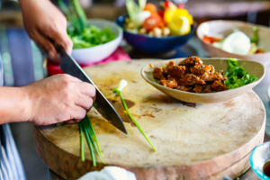 Individual preparing food on a cutting board.