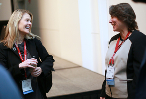 two females talking to one another while smiling at the other