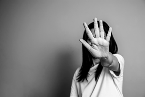 Black and white photo of young woman holding her hand palm forward.