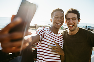 two males smile and pose for a selfie together