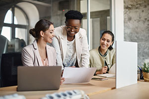 Group of professionals collaborating around a laptop.