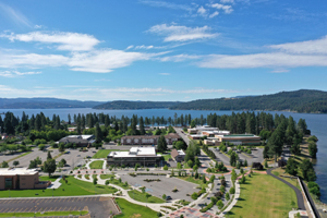 North Idaho College's campus next to a body of water on a sunny day with blue skies