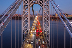 Photograph of a bridge full of cars over a river.