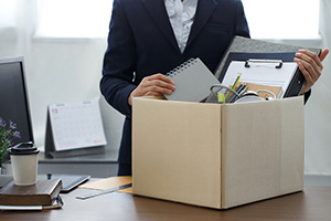 Individual packing up their office in a box.