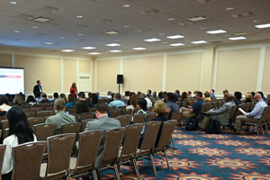 people sitting in an event space with brown backed chairs