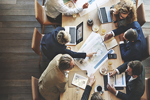 Group of business professionals meeting around a table from an overhead perspective.