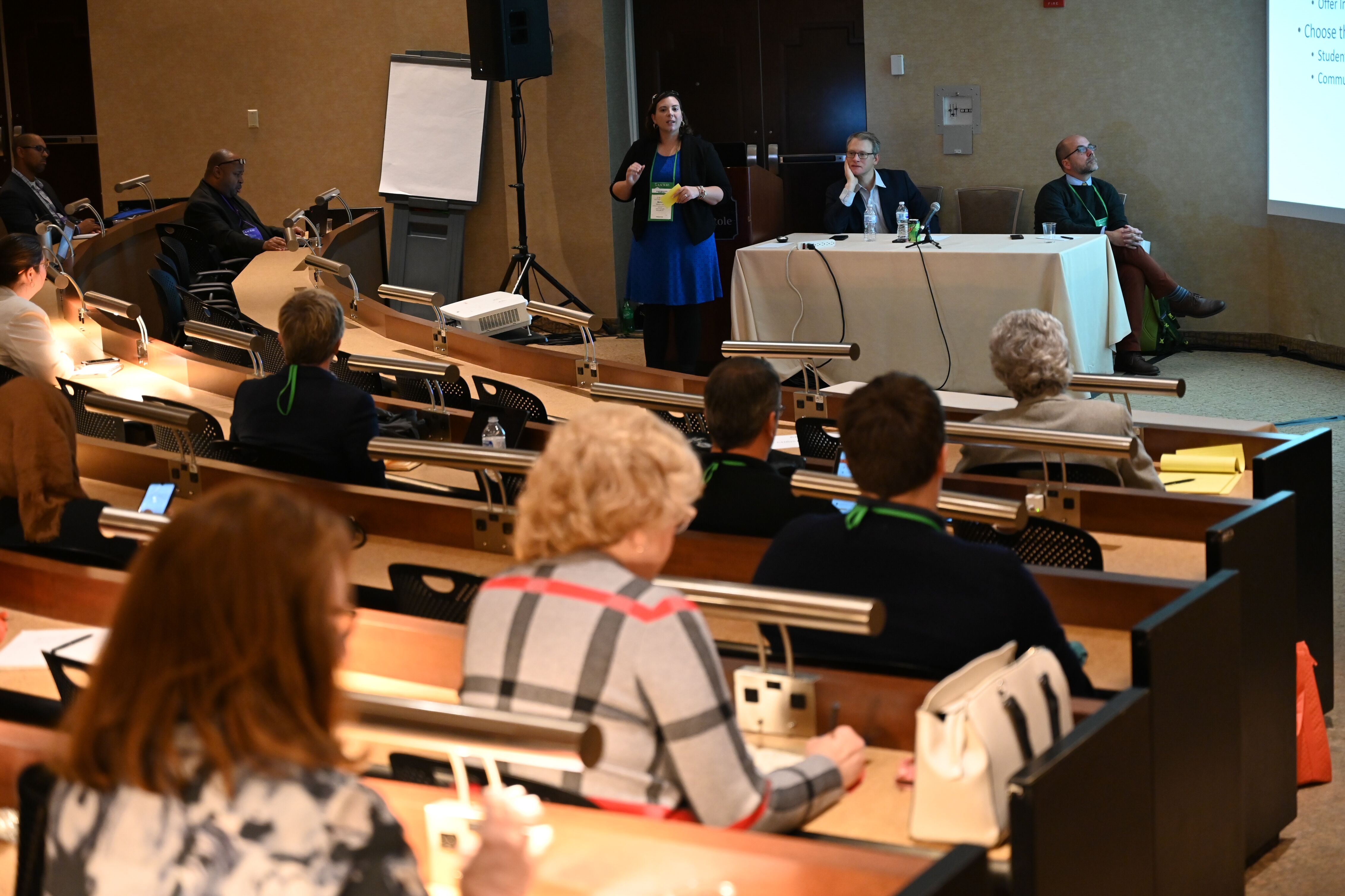 audience members sitting in a lecture hall listening to a panel