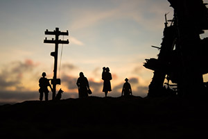 Shadowed image of a family walking while another in miliary clothing stands still.