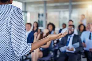 female leads a discussion as diverse group of business people take notes