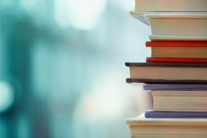 stack of books with a blurred turquoise background 