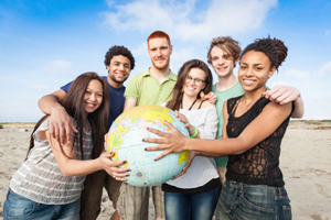 diverse group of students holding a globe together