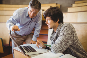 student showing a professor their laptop as the two discuss