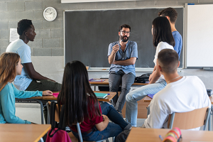 Group of university students consulting with a professor.