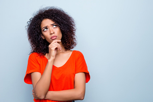 female in brightly colored blouse stares off into the distance as though she is thinking