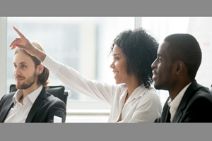 businesswomen raises her hand, appearing to answer a question 