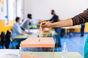 Photograph of an individual submitting a ballot.