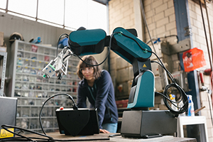 Photograph of an individual using a 6 axis computer controled arm.