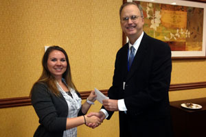 Male and female smiling as they shake hands while exchange a document.