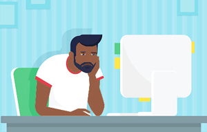 Illustrated male of color slouching over as he drearily looks at a computer monitor in front of him at a desk.
