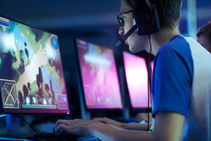 Young male wearing a headset as he plays a computer game.