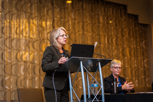 Photo of LesLee Clauson Eicher speaking at a podium at TAICEP 2018.