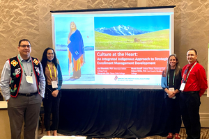 4 people stand in front of a projector displaying an image of nature with the words "culture at the heart" visible